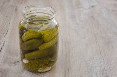 Ahşap bir arka planda salatalık turşusu kavanozu. Ev yapımı turşu..
