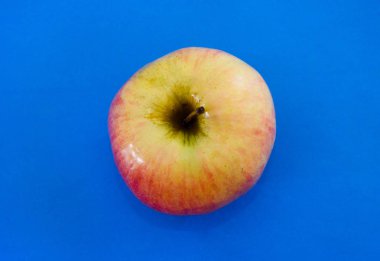 Mavi arka planda bir elma. Yakın plan. Yukarıdan görüntüle.
