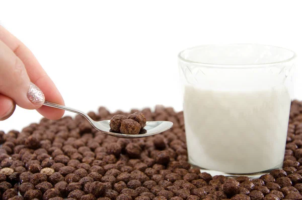 Glas Milch Löffel Der Hand Und Schokoladenkugeln Auf Einem Weißen — Stockfoto