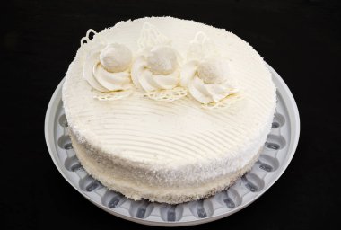 Lezzetli, siyah arka planda kremalı beyaz pasta. Yukarıdan görüntüle.