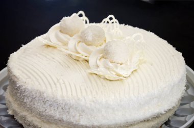 Lezzetli, siyah arka planda kremalı beyaz pasta. Yukarıdan görüntüle.