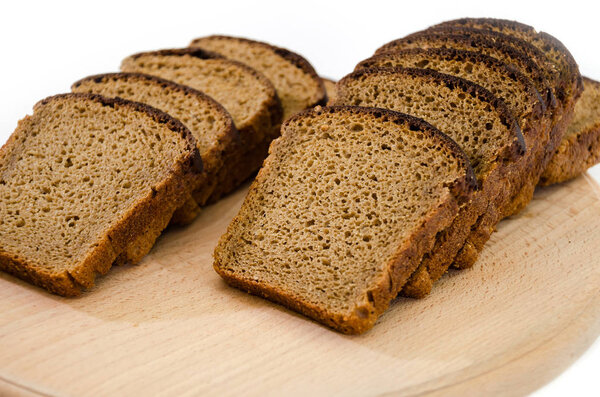 Sliced rye bread on a cutting board. Isolated on white. Delicious, brown bread.