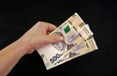 500 Hryvnia elinde siyah bir arkaplanda.