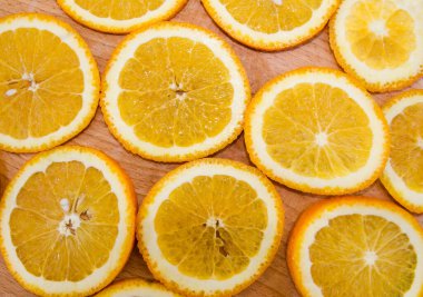 Arkaplan için turuncu slaytlar. Ahşap bir arka planda dilimlenmiş portakal. Yukarıdan bak. Portakal dilimleri ile güzel bir arkaplan.