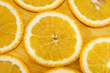 Arkaplan için turuncu slaytlar. Ahşap bir arka planda dilimlenmiş portakal. Yukarıdan bak. Portakal dilimleri ile güzel bir arkaplan.