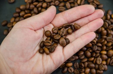 Kahve çekirdeklerinin arka planında kavrulmuş kahve çekirdekleri. Yukarıdan bak. Yakın plan..