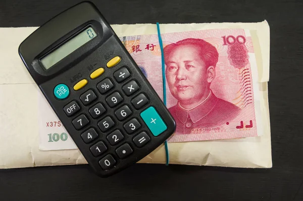 用黑色背景的中国钱和计算器组成的厚厚的信封 业务概念 — 图库照片