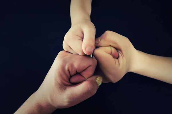 Hands of a family team.. Pile of fists. Mom, dad and baby together concept of caring for loved ones, support, happiness, love, trust, spending time together.