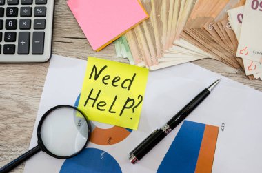 İş konsepti. Para, hesap makinesi ve iş grafiği masada. Yazıtın yardıma ihtiyacı var..