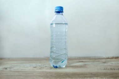 Tahta bir masanın üzerinde küçük bir şişe temiz su..