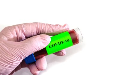 Kavramsal fotoğrafçılık Coronavirus testi: Bir el test tüpünü tutar. Beyaz arka planda test tüpü olan tıbbi bir eldiven verin. Boşluğu kopyala.