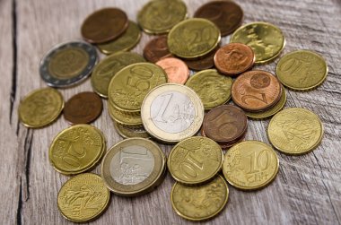 Ahşap arka planda madeni paralar. Masada bir yığın bozuk para var. Yakın plan..