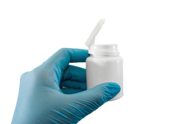 Mavi eldiven, beyaz arka planda izole edilmiş haplarla beyaz kapasite taşır..