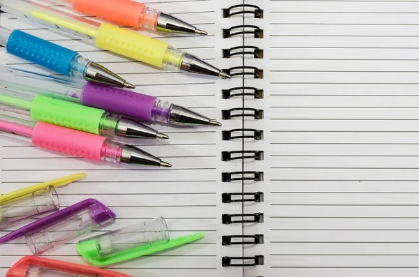 multi-colored pens on an open notebook. Close-up. Education concept.