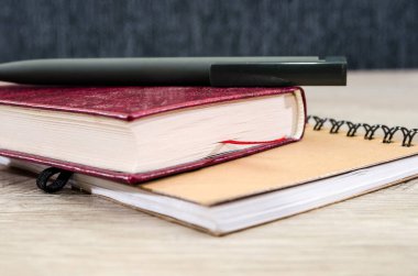 Defter, kitap ve kalem masaya. Yakın plan..