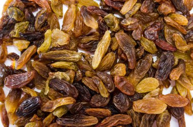 Kuru üzümlü arka plan. Beyaz üzerine uzun hafif kuru üzümler.