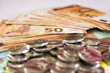 Bozuk paraların arka planında Avro banknotları. Çok para. Ekonomik büyüme, kalkınma stratejisi.