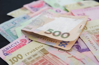 Siyah arkaplanda farklı hrivniyalar ve hesap makineleri. Bir sürü Ukrayna parası..