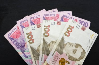 Siyah arka planda 100 ve 200 Hryvnia. İş konsepti.