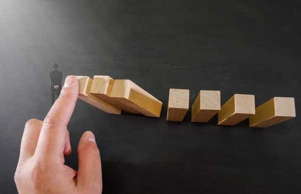 Hand Stops Falling Wooden Blocks Miniature Businessman Black Background — Stock Photo, Image