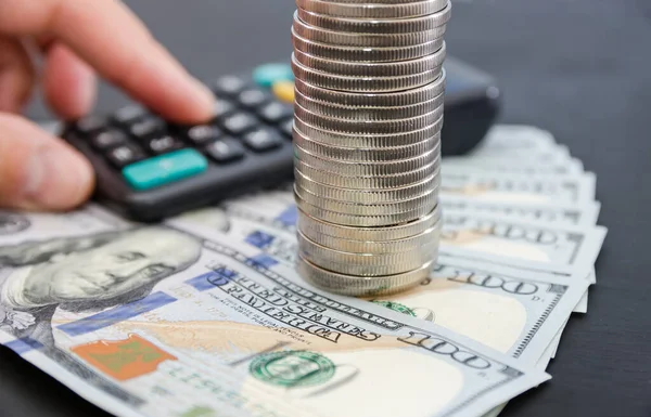 calculator on the background of stacks of coins and dollars.Saving money, business growth or investment concept.stack of coins in dollars. Calculate revenue using a calculator.