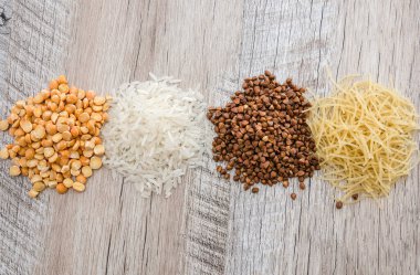 Uzun pirinç, bezelye, makarna ve ahşap zemin üzerinde karabuğday. Yukarıdan bak. Farklı tahıl ve baklagiller.