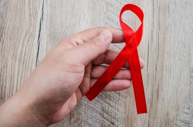 AIDS kavramı. Ahşap arka planda kırmızı kurdele. Yakın plan..