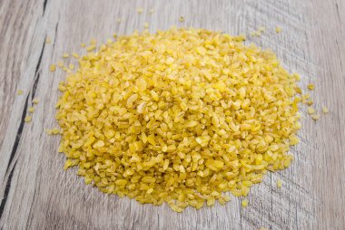 Ahşap bir arka planda bulgur büyütür..