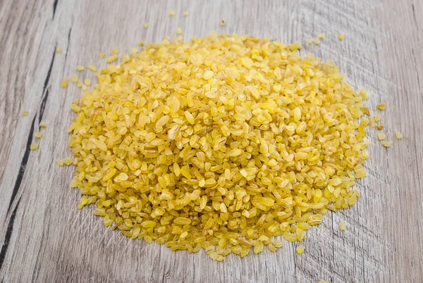 Ahşap bir arka planda bulgur büyütür..