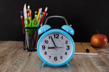 Masada mavi alarm, elma kalemleri ve kalemler var..