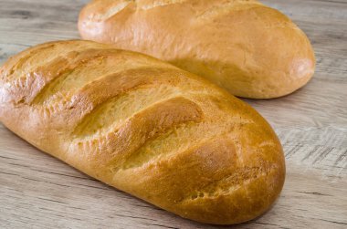 Ahşap arka planda iki somun ekmek. Yakın plan. Beyaz Ukrayna ekmeği.