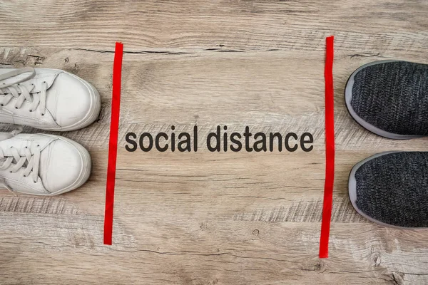 The concept of social distance. Prevention of virus infection. Shoes on a wooden background.