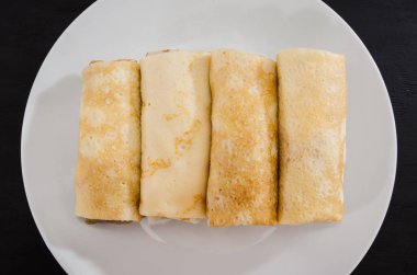 Siyah arka planda beyaz tabakta süzme peynirli leziz gözlemeler..