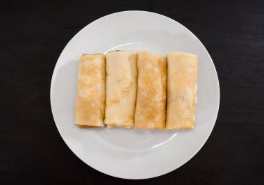 Siyah arka planda beyaz tabakta süzme peynirli leziz gözlemeler..