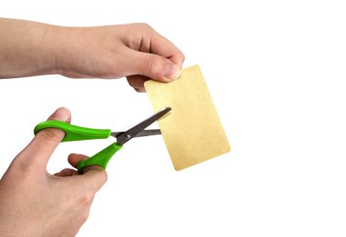 Ellerindeki makas beyaz arkaplanda sarı bir plastik kart kesti..