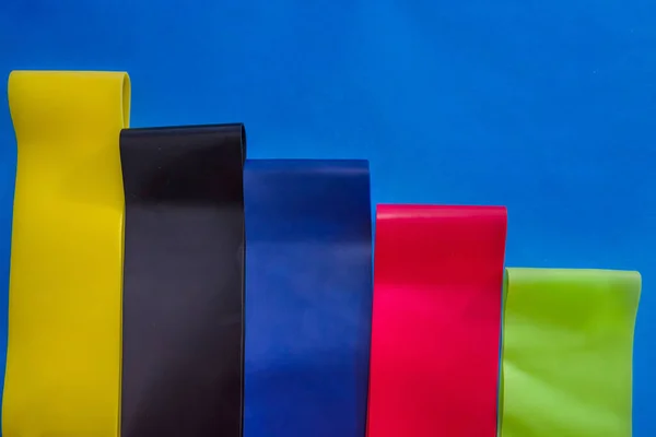 colored rubber bands for fitness on a blue background. Close-up.