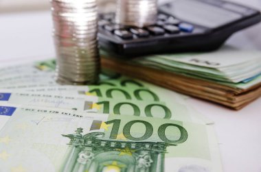 Avro banknotları, hesap makinesi ve bozuk paralar için 100 euro. İş konsepti.
