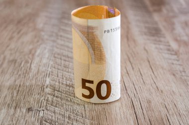 Tahta bir arka planda yaklaşık 50 Euro 'luk bir banknot..