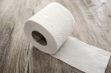 Ahşap arka planda beyaz tuvalet kağıdı.