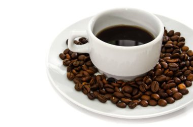 Beyaz tabakta beyaz bir fincan kahve. Kahve çekirdeği. Beyaz arkaplan.