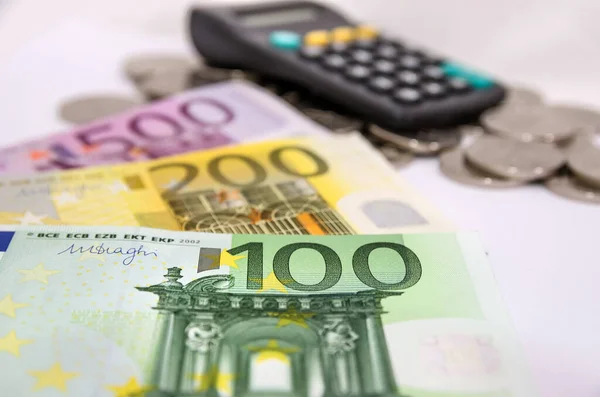 100 200 500ユーロ紙幣に白い計算機と硬貨 — ストック写真