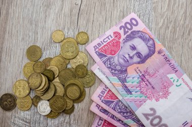 200 Hryvnia ve ahşap arka planda madeni paralar. Yakın plan. Yukarıdan görüntüle.