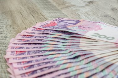 Tahta arka planda 200 Hryvnia değerinde bir sürü banknot var. Bir sürü Ukrayna parası..