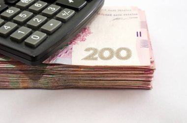 200 hryvnia ve hesap makinesi beyaz üzerine istiflenmiş. Yakın plan..