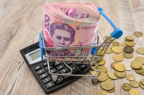 Bir alışveriş arabasında, bozuk paralar ve hesap makinesiyle 200 hryvnia yuvarlandı. Yakın plan..
