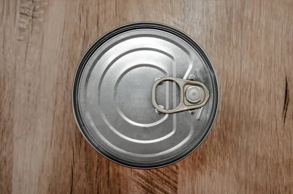 Tin can on a wooden background. View from above. Close-up.