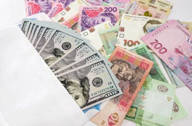 Beyaz bir zarf içinde dolar ve farklı hryvnialar. İş konsepti.