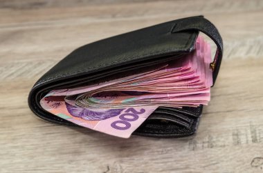 Ahşap arka planda bir adamın cüzdanında bir sürü Hryvnia var..