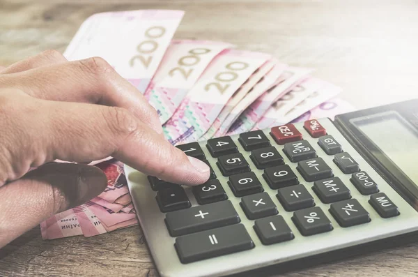 Kadın eli hesap makinesinde Ukrayna 'nın arka planına karşı bir şey yazdırıyor. Yakın plan..