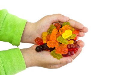 Birçok renkli jöle ayıcığı beyaz arka planda izole bir şekilde çocukların ellerinde. Yukarıdan görüntüle.